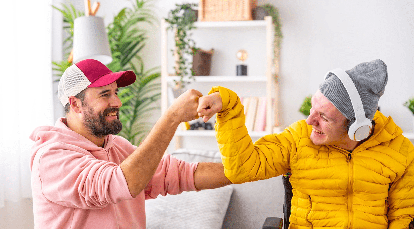 Two friends fist-bumping in a cozy room.