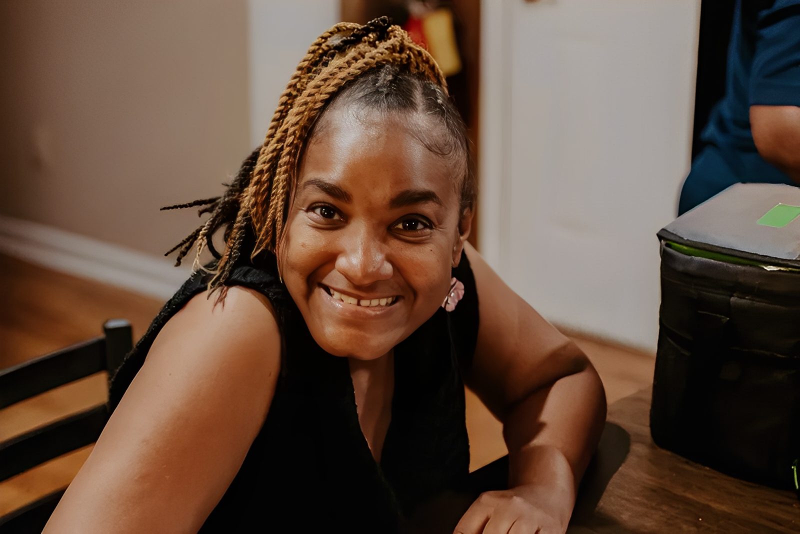 Smiling woman sitting at a table indoors.